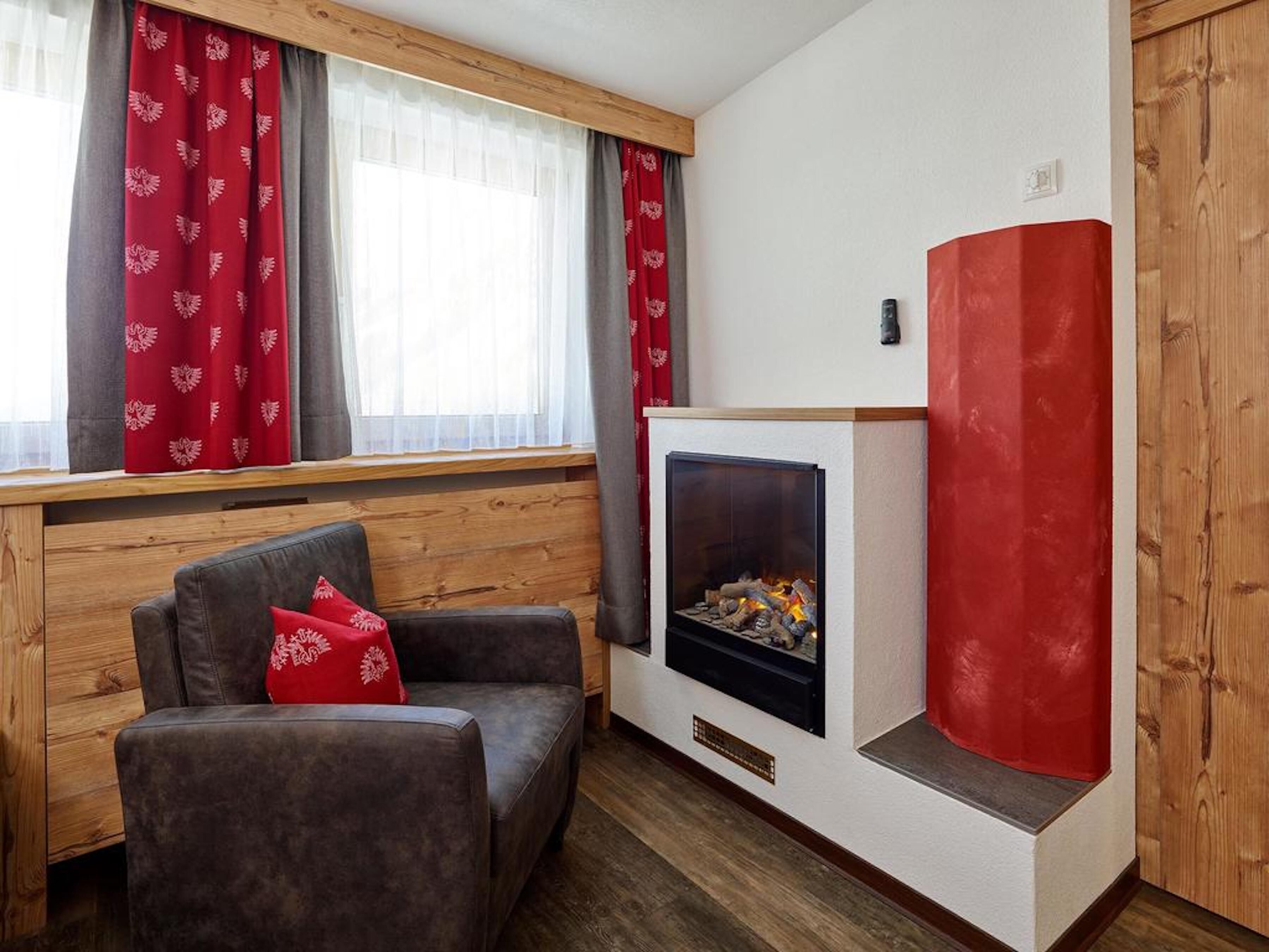 Una sala acogedora con chimenea, banco de madera y un sillón cómodo.