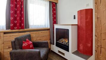 Una sala acogedora con chimenea, banco de madera y un sillón cómodo.