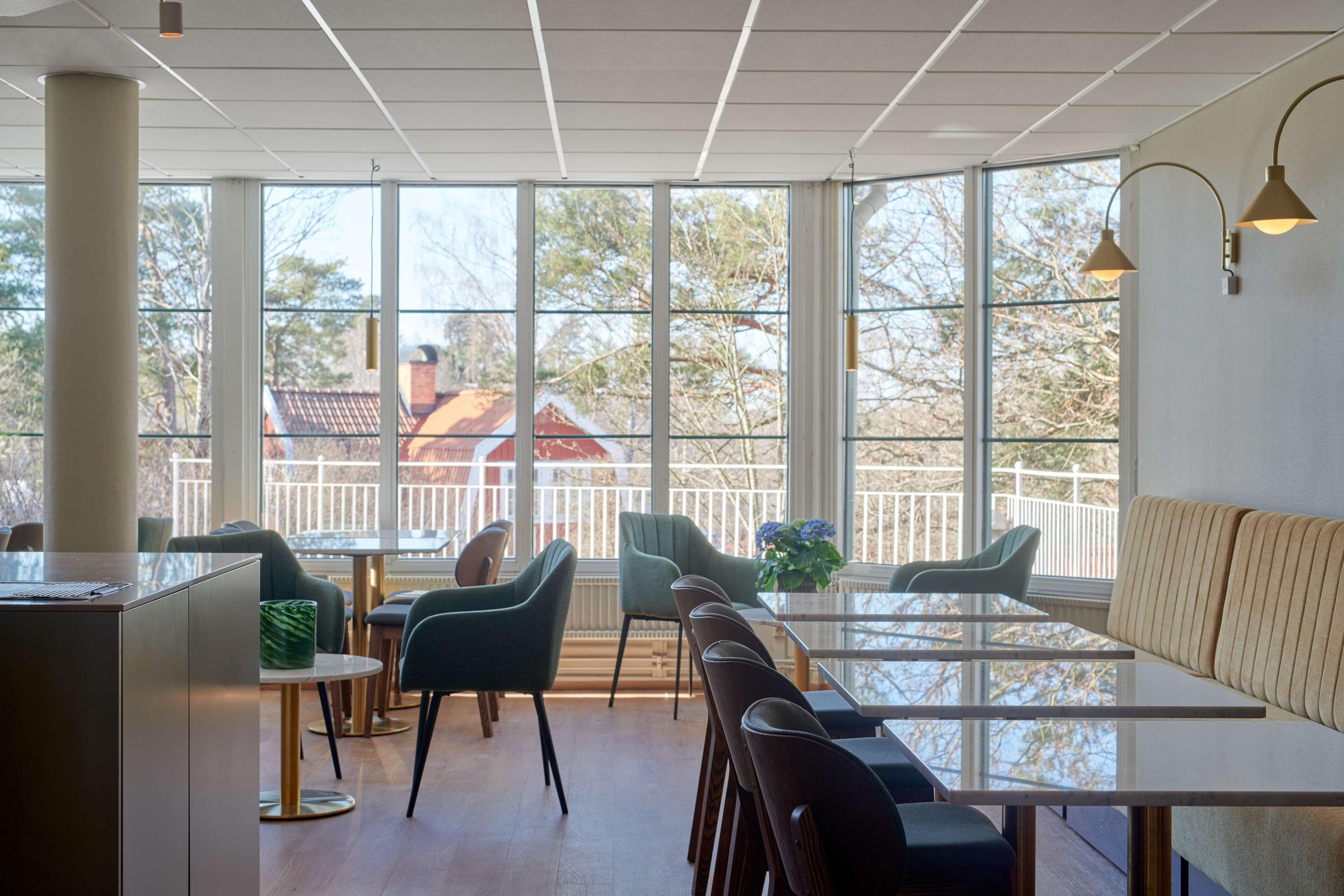 Un comedor moderno con ventanas amplias, una mesa larga y varias sillas.