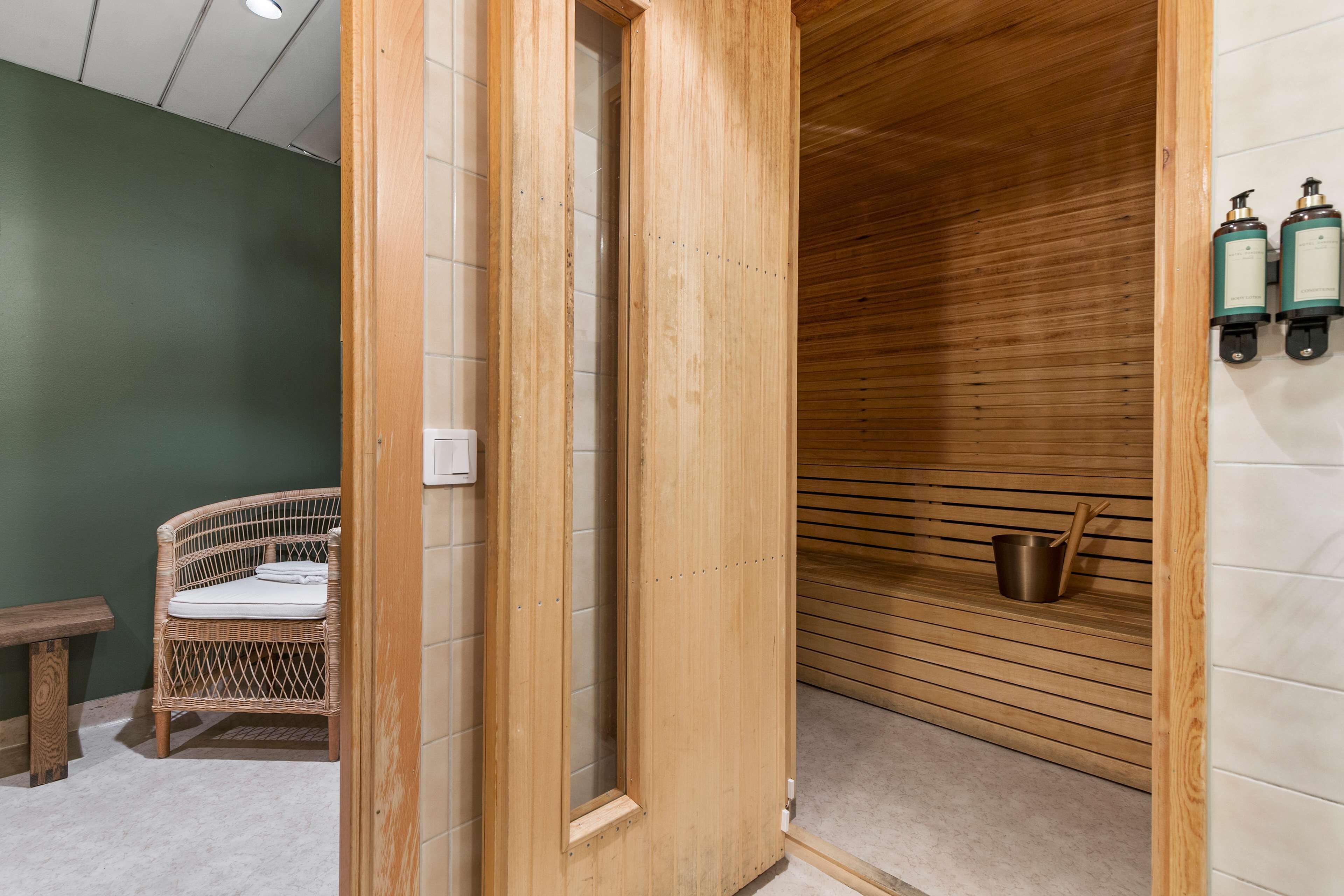 A wooden sauna with a bench and two bottles on the wall.