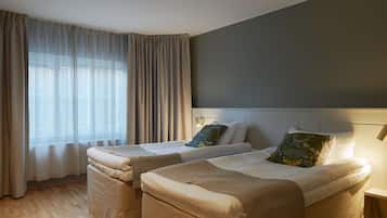 Une chambre d’hôtel avec deux lits, une grande fenêtre avec des rideaux et une tête de lit moderne.