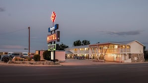 Un motel con un letrero, un restaurante y un edificio con un balcón.