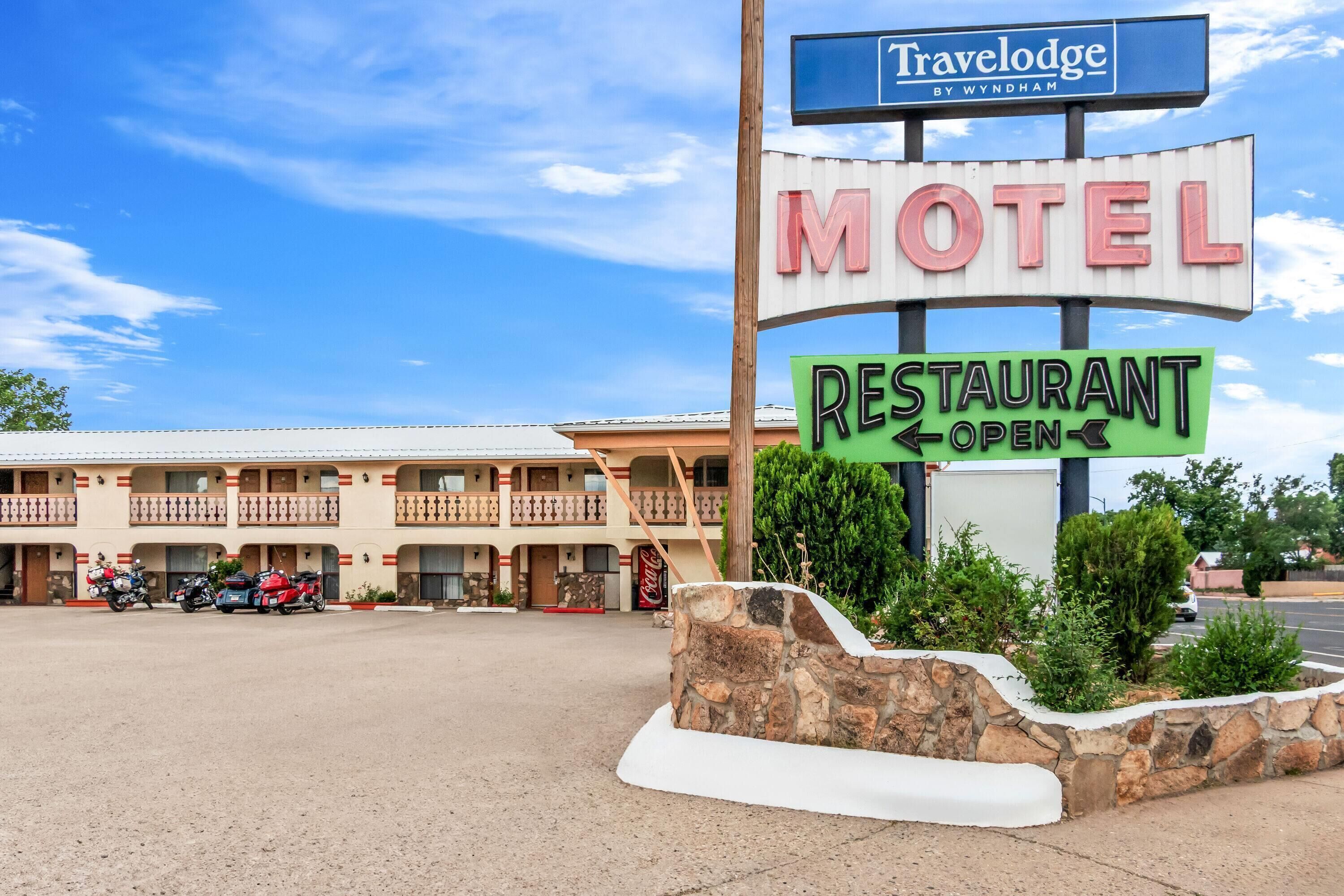 Un motel con un cartel que indica que hay un restaurante abierto.