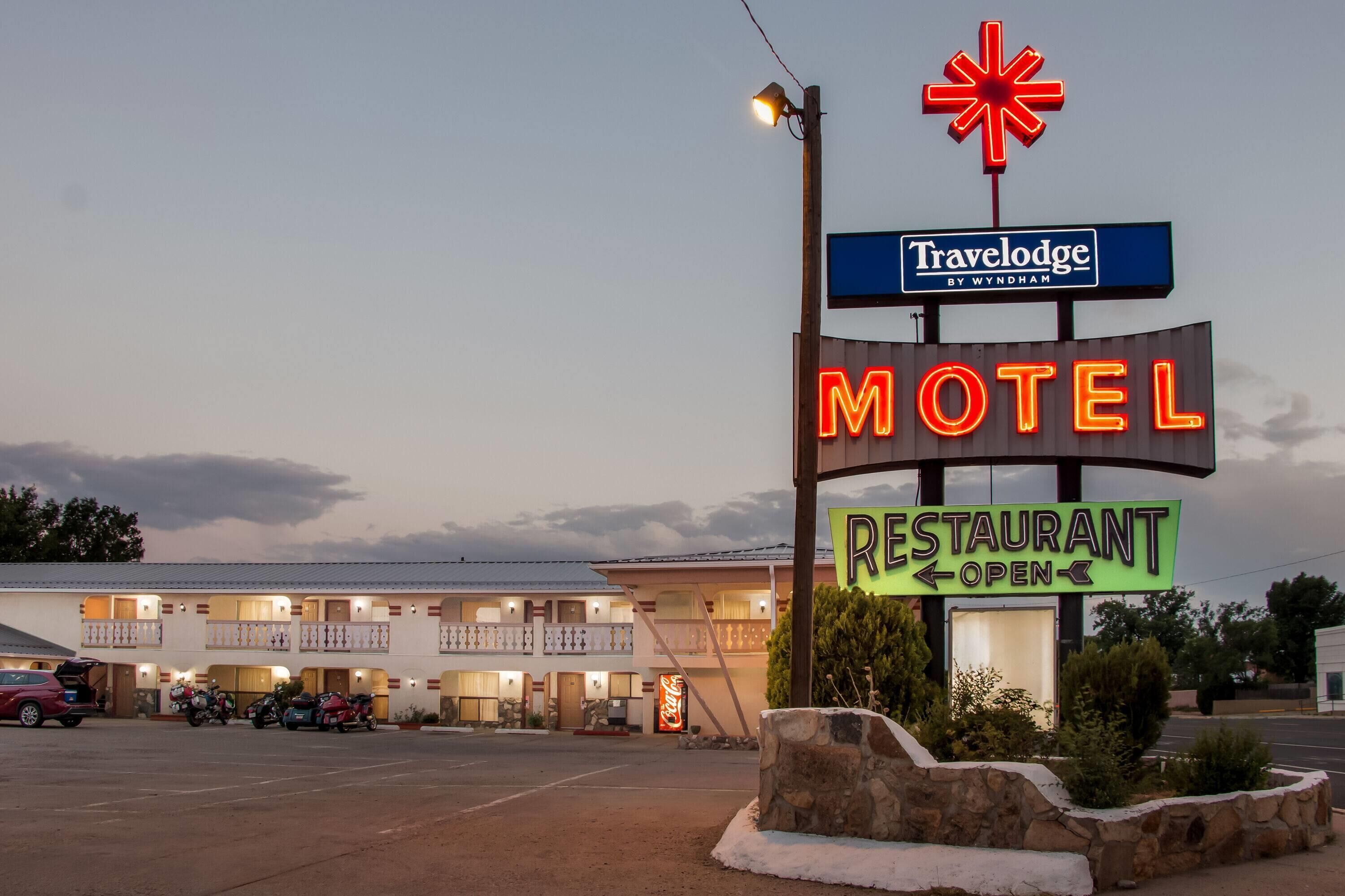 Un motel con un letrero de neón que indica que el restaurante está abierto.