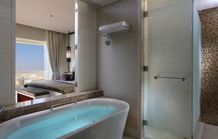 A modern bathroom with a freestanding bathtub, a glass shower enclosure, and a towel rack.
