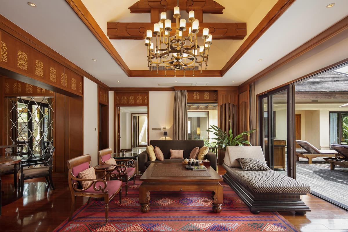 A spacious living area with a large sofa, a coffee table, and a chandelier.
