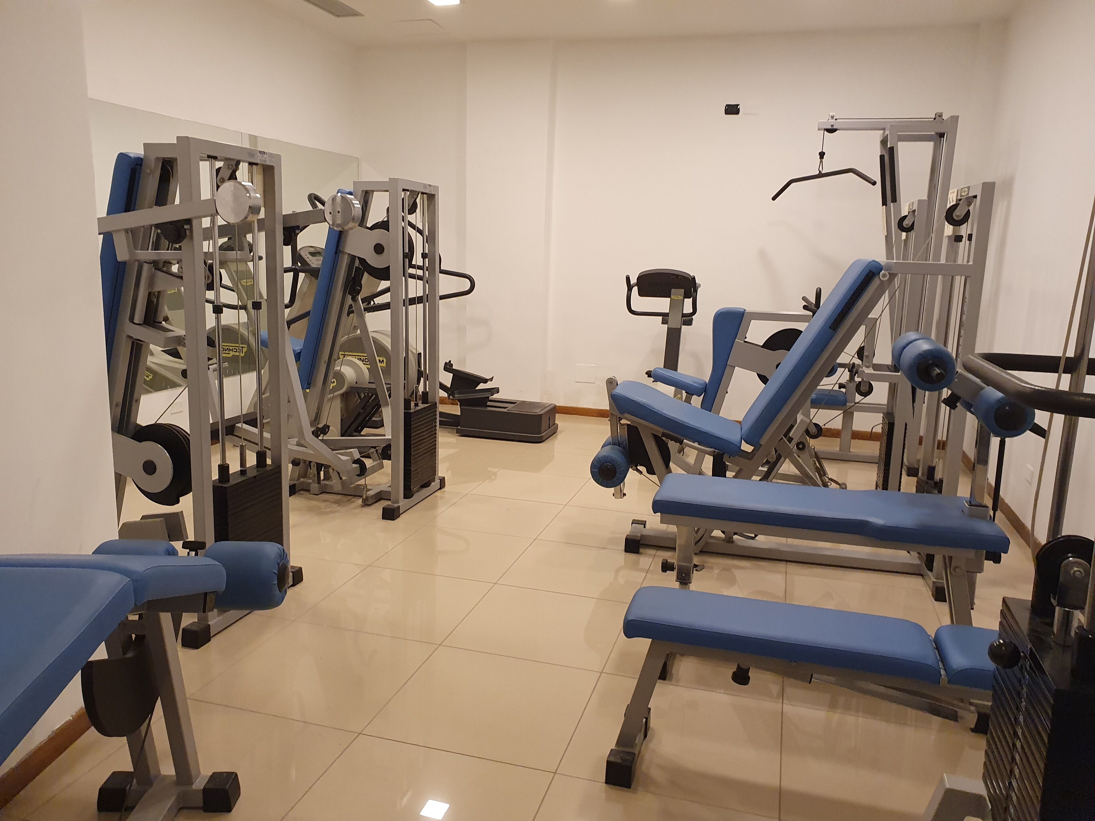 A gym with various exercise equipment, including weight machines and benches.