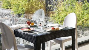 Een eettafel gedekt met borden eten, een kopje en een glazen stolp.