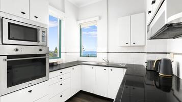 Apartamento standard, 3 quartos, cozinha, vista para a praia (3 Bdrm Beach View) | Cozinha privada | Geladeira grande, micro-ondas, cooktop, lava-louças