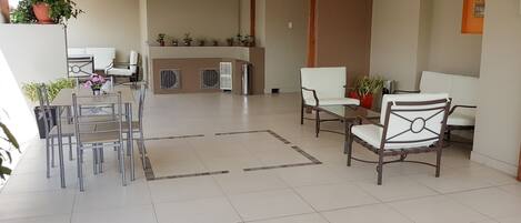 A spacious lobby with a reception desk, seating area, and a dining setup.