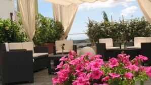 An outdoor seating area with wicker furniture and potted plants. - Vittoria (San Giovanni Rotondo)