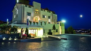 A modern hotel with a prominent entrance, outdoor seating area, and a swimming pool. - Vittoria (San Giovanni Rotondo)