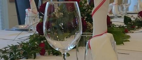 A table set for a formal dinner with a menu, wine glass, and folded napkin.