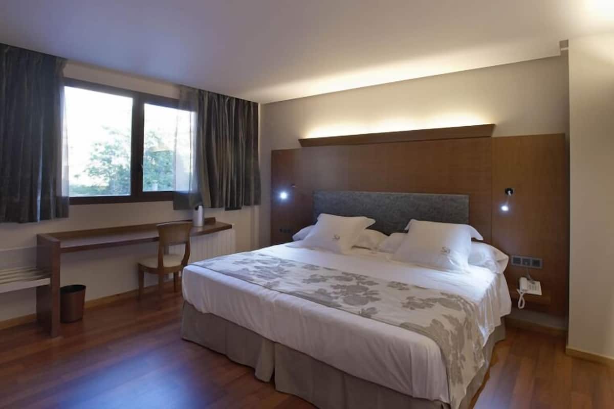Un dormitorio con cama, escritorio y silla.