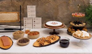 A table with various food items including pastries, fruits, and a cake. - Hotel Sancho Abarca Petit SPA (Huesca)