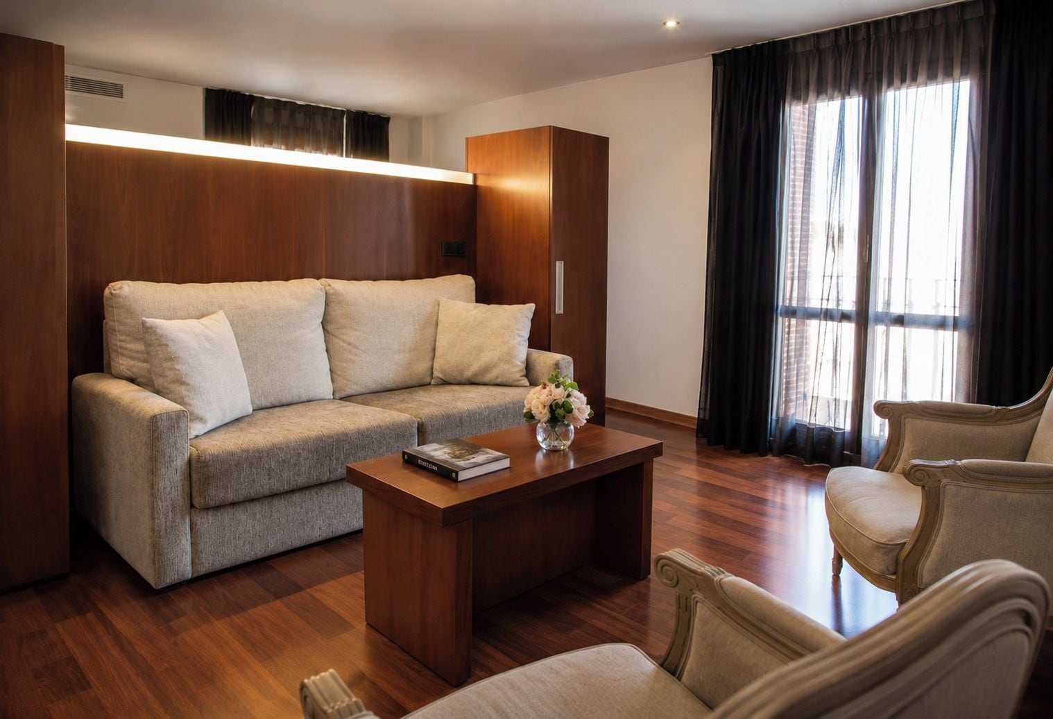 Una sala moderna con un sofá, una mesa de centro y dos sillones.