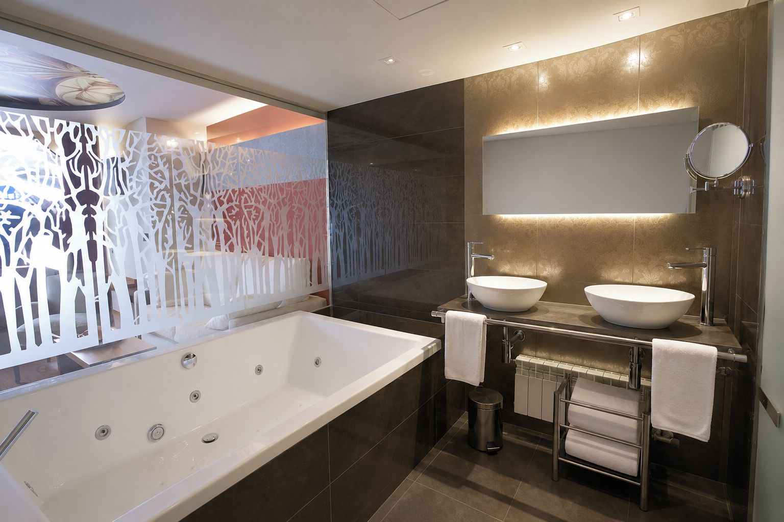 Un baño moderno con una bañera grande, dos lavamanos sobre encimera, un espejo y un panel decorativo en la pared.