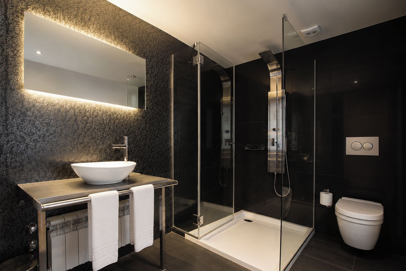 Une salle de bain moderne avec une douche à parois de verre, un lavabo blanc et des toilettes.