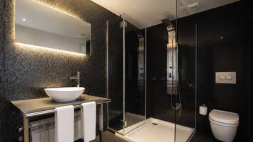 Une salle de bain moderne avec une douche à parois de verre, un lavabo blanc et des toilettes.