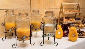 Ein Frühstücksbuffet mit verschiedenen Saftspendern und einer Auswahl an Backwaren.