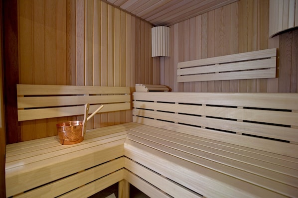 A wooden sauna with benches and a copper bucket. - Hotel Sancho Abarca Petit SPA (Huesca)