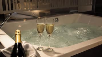 Un jacuzzi con dos copas de champán y una botella.