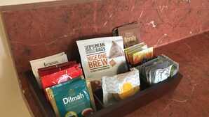 En bakke med kaffe og te, blandt andet mærker som JED'S, Dilmah og Cocoa Naturally, står på en marmor bordplade.