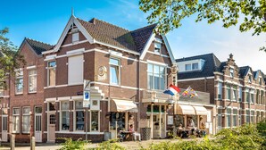 A traditional brick building with a cafe on the ground floor and a restaurant on the second floor. - Hotel Stad en Land (Alkmaar)