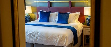 A hotel room with a bed, bedside tables, lamps, and a headboard.