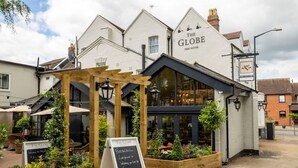 A traditional pub named 'The Globe Free House' with a wooden pergola, outdoor seating, and a signboard. - The Globe, Warwick, Warwickshire - Brunning & Price (Warwick)