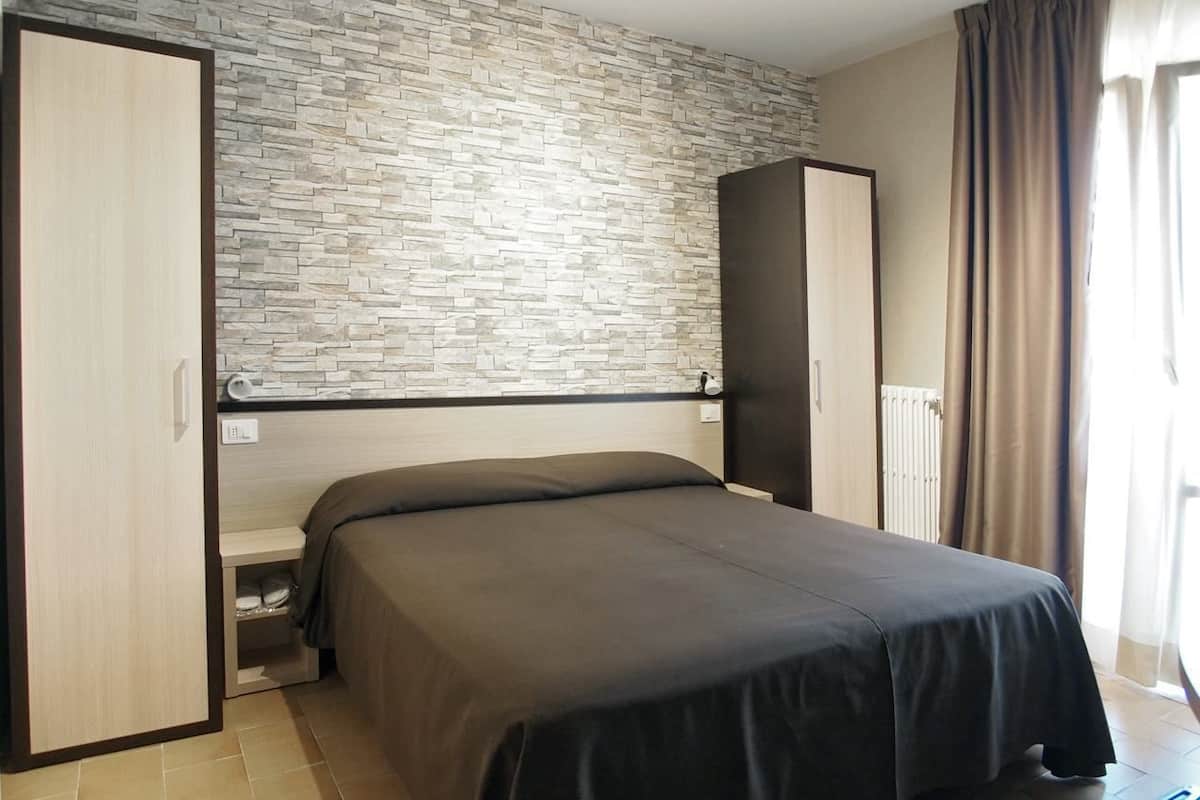 A bedroom with a bed, a wardrobe, and a built-in bench.
