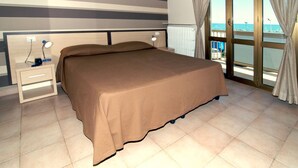 Un dormitorio con una cama grande, una mesita de noche con lámpara, una ventana con cortinas y vista al mar.