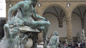 Un edificio histórico con arcos y estatuas.