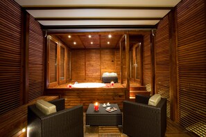 A spa room with wooden walls, a hot tub, and wicker furniture. - Style Hotel (Milan)