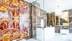 A modern reception area with a marble wall, glass partitions, and contemporary furnishings. - Style Hotel (Milan)