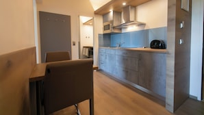 A modern kitchen with wooden cabinets, a microwave, and a coffee machine.