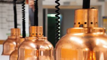 A series of copper-colored pendant lights hanging from a ceiling.