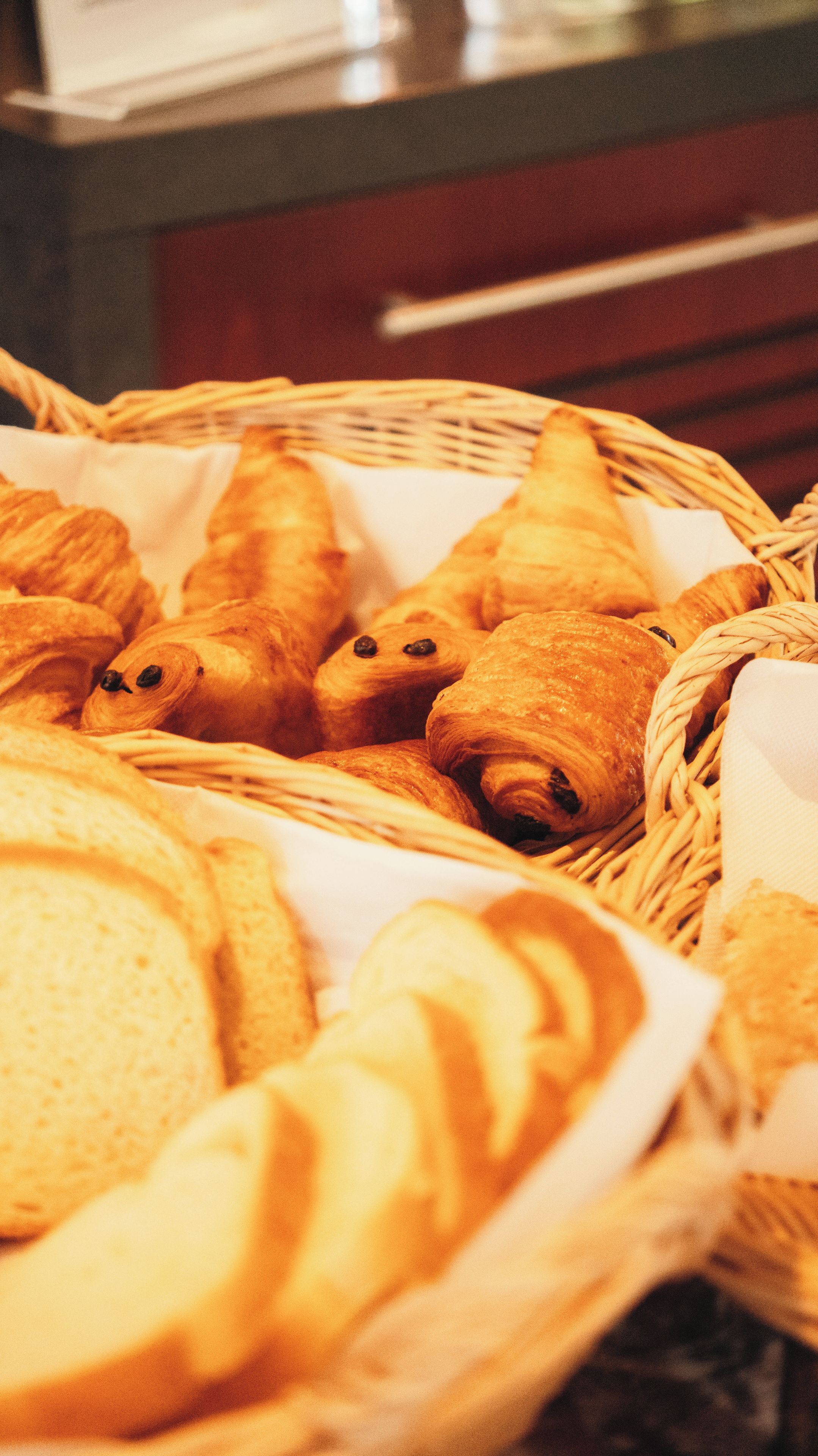 A basket filled with various types of bread and pastries.