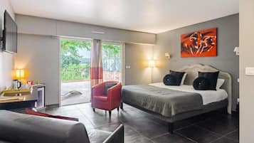Ein modernes Schlafzimmer mit einem Bett, einem roten Sessel, einem Schreibtisch mit Lampe und einem Fernseher.