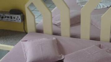 Uma cama com cabeceira, travesseiros e cobertor.