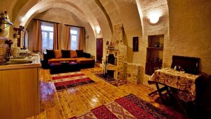 Una habitación acogedora con chimenea de piedra, suelo de madera y un sofá.