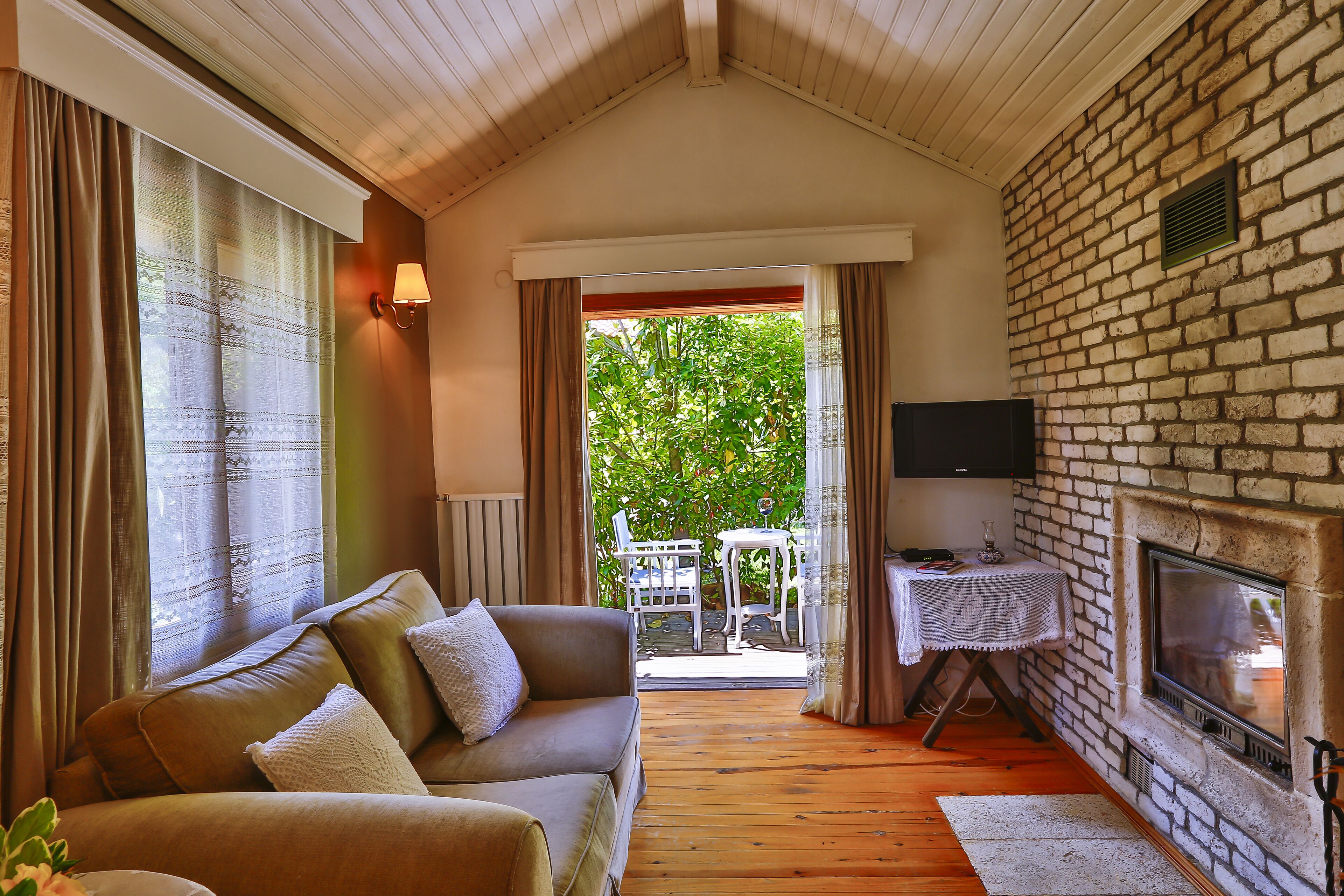 Uma sala de estar aconchegante com lareira, um sofá e vista para o exterior.
