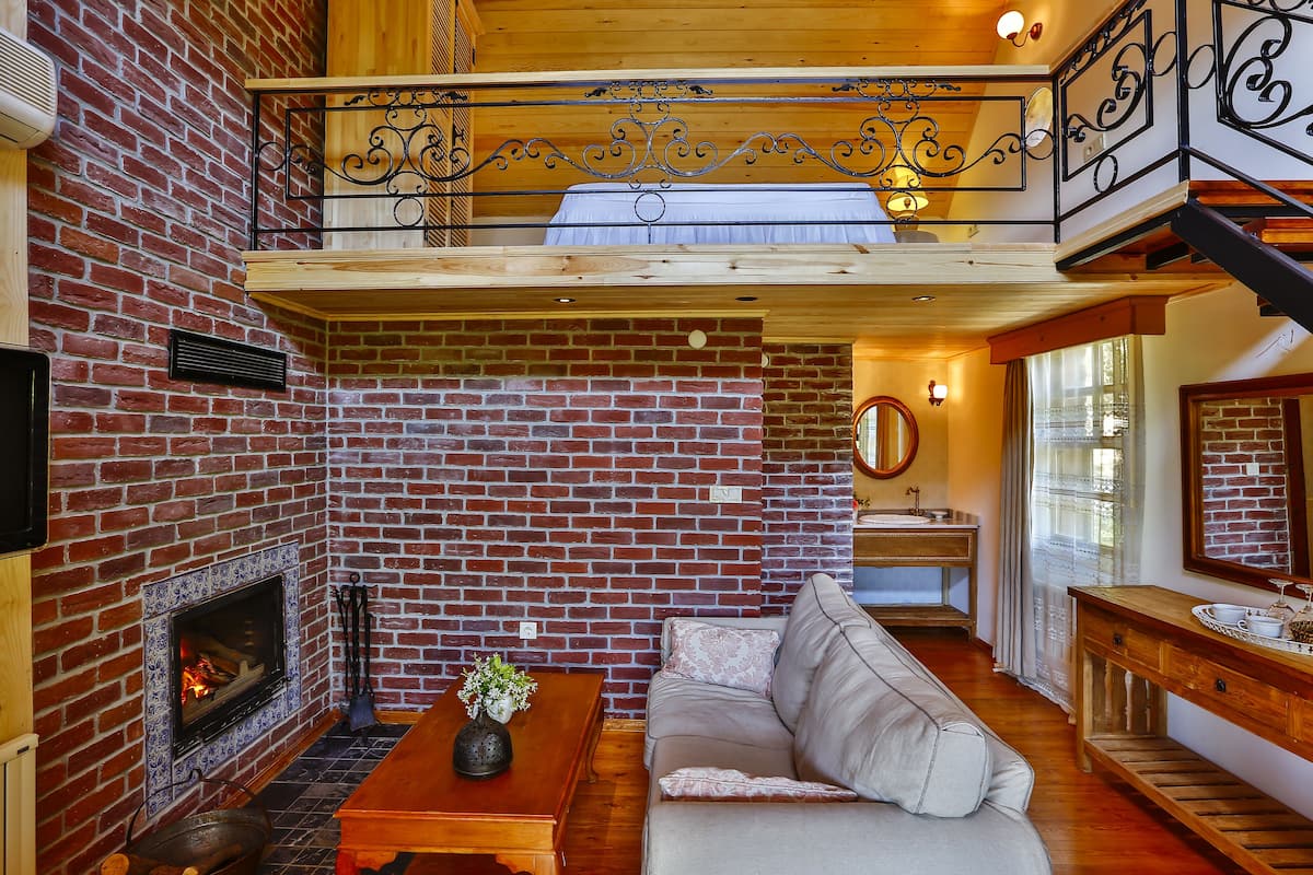 A cozy living room with a fireplace, a sofa, and a wooden table.