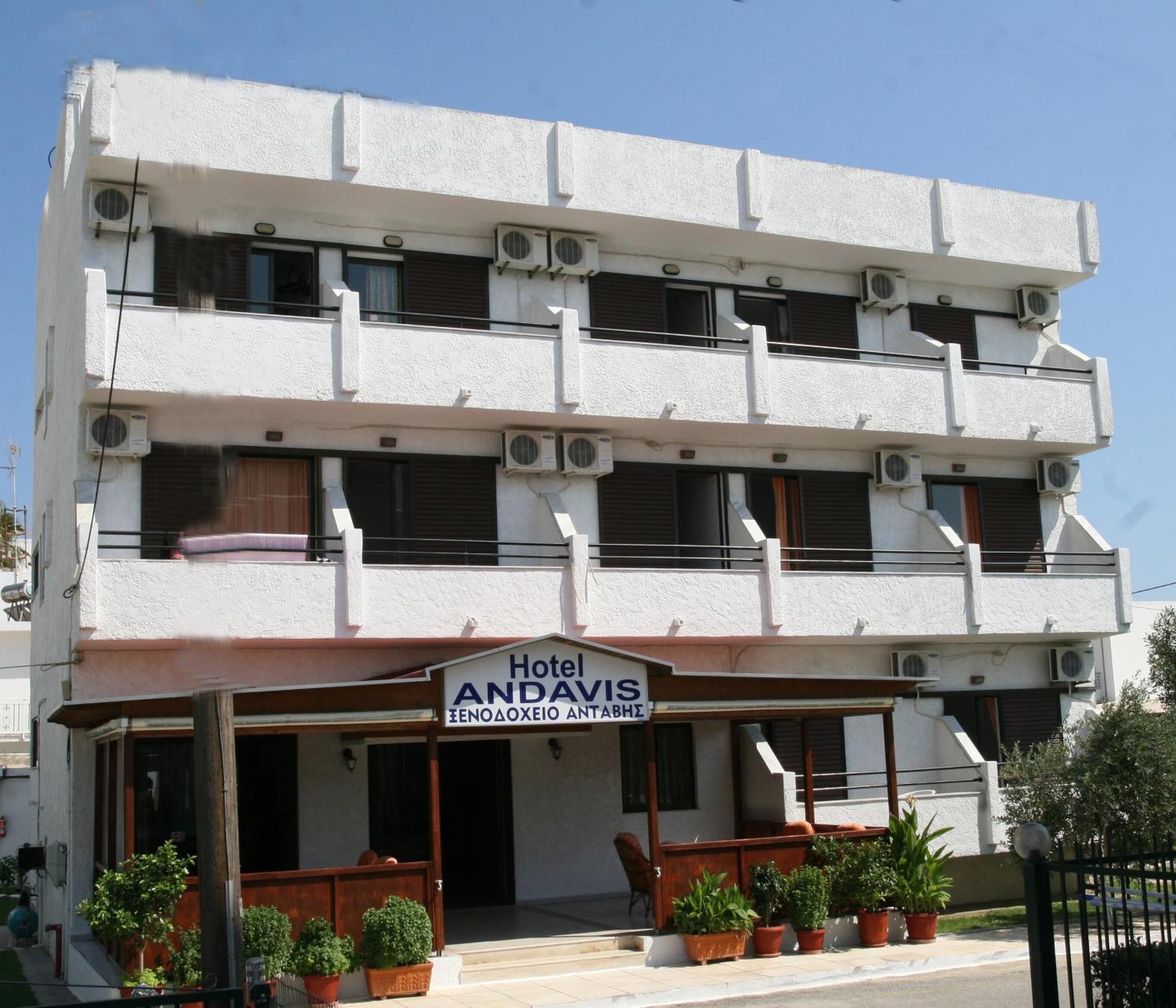 Un hotel de varios pisos con un letrero que dice "Hotel ANDAVIS ENOΔOXEIO ANTABHE".