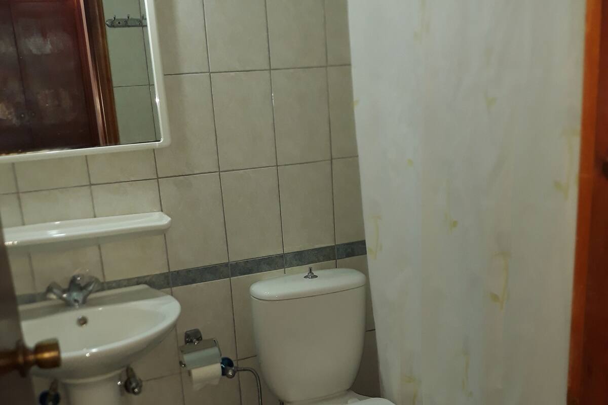 A small bathroom with a sink, toilet, and a mirror.