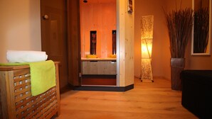 Un interior de madera con un banco, una mesita con una toalla y una planta decorativa.
