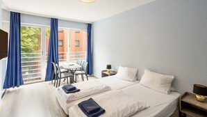 A hotel room with two beds, a desk, and a chair. - Icke Apartments (Berlin)