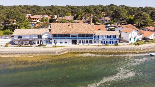 Un edificio frente al mar con tejado de baldosas.