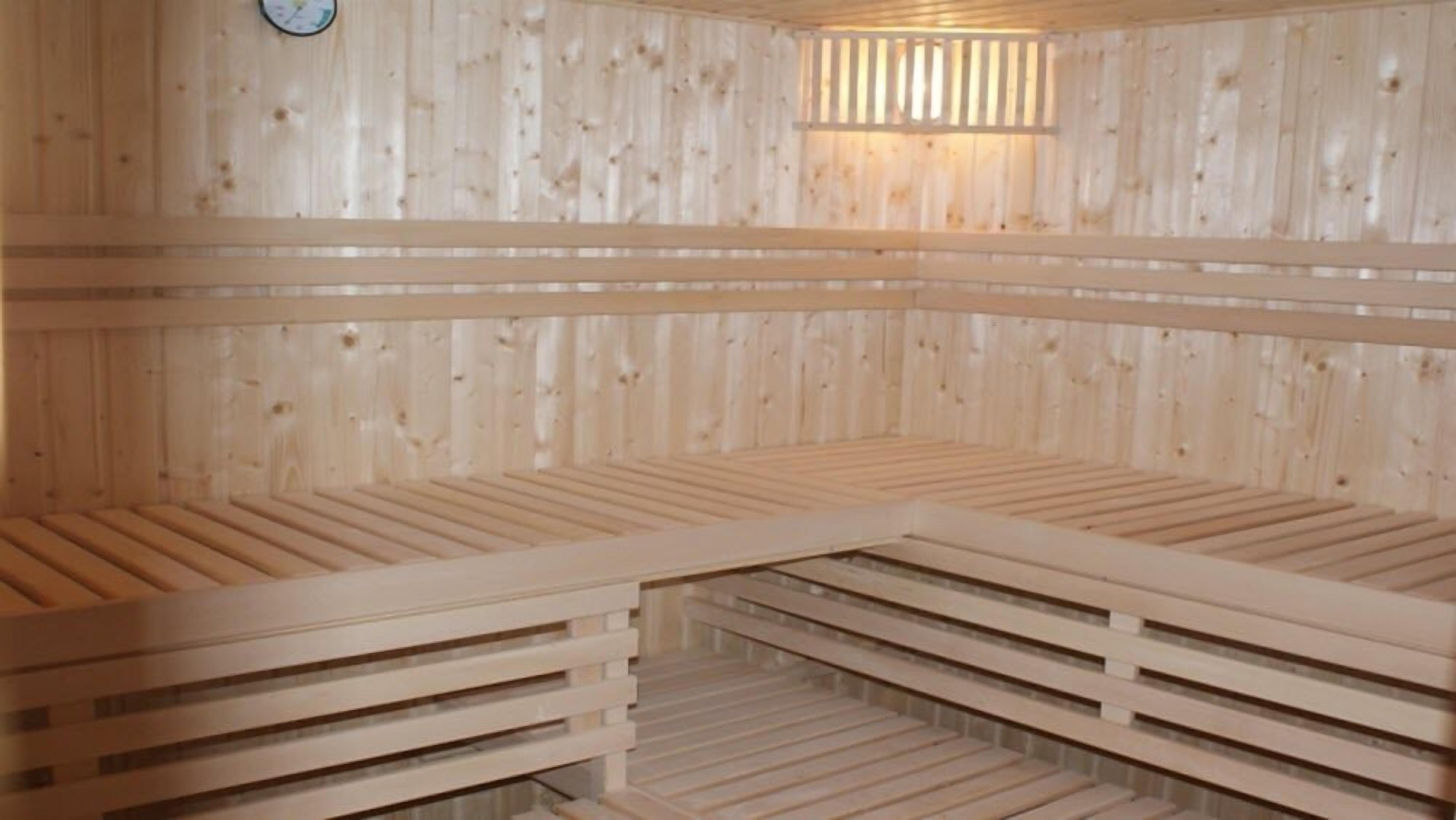 A sauna with wooden benches and a slanted ceiling.