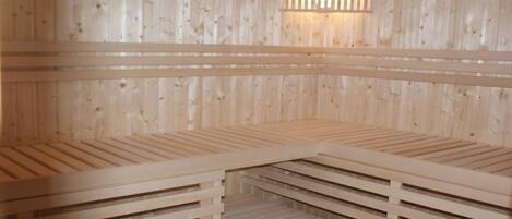 A sauna with wooden benches and a slanted ceiling.